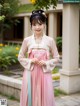 A woman in a pink hanbok is posing for a picture.