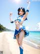 A woman in a blue and white outfit on a beach.