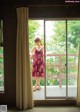 A woman standing in front of a sliding glass door.