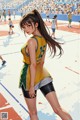 A woman in a yellow and green uniform standing on a basketball court.