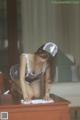 A woman in a maid outfit cleaning a desk.