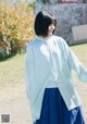 A woman wearing a blue skirt and a light blue shirt.